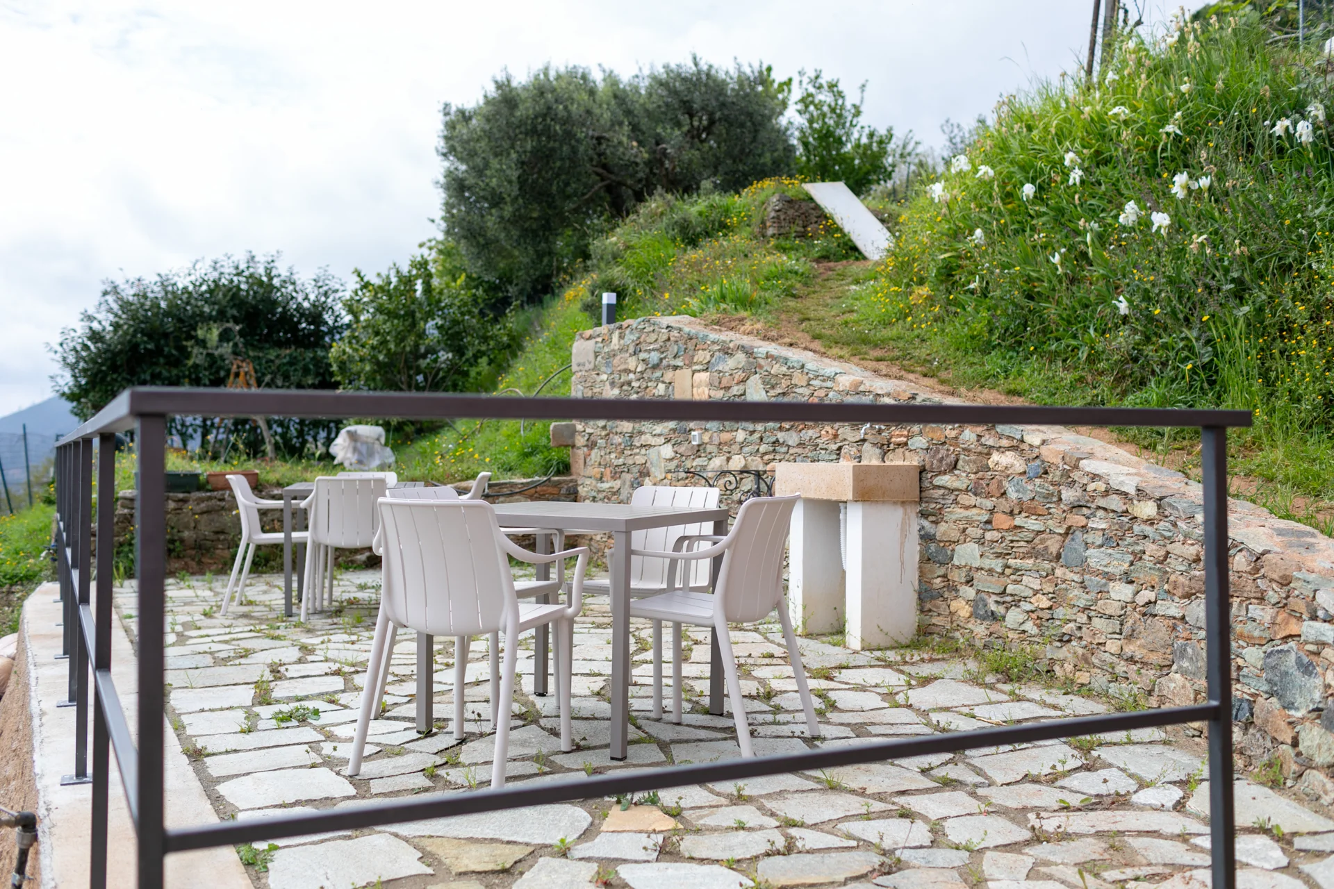 Terrazza in pietra con tavolini e vegetazione